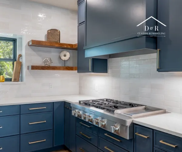 A modern kitchen featuring a large white marble island with blue velvet stools.