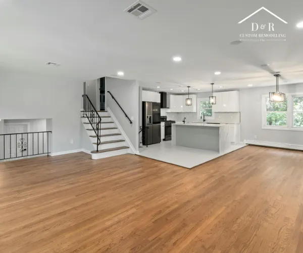 A wide-angle view of a spacious home renovation with polished hardwood floors.